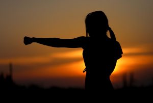 silhouette of a woman doing karate during sunset